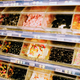 Plastic tubs of bulk gummi candy, including lots of licorice, in a grocery store aisle